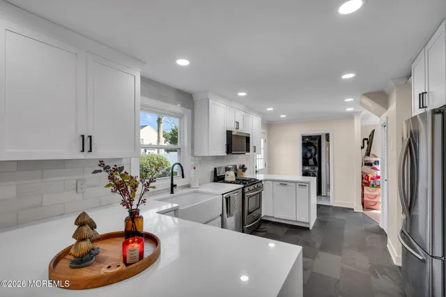 a kitchen with stainless steel appliances granite countertop a sink a refrigerator and a refrigerator