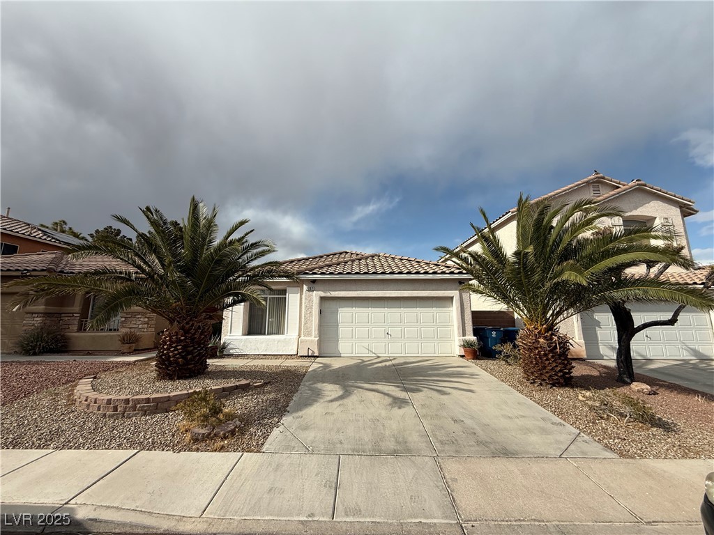 7062 Russell Ranch Avenue Las Vegas, NV 89113 - Photo 1 of 32 View of front of house with driveway, stucco siding, an attached garage, and a tiled roof