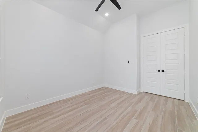 an empty room with a window and a ceiling fan