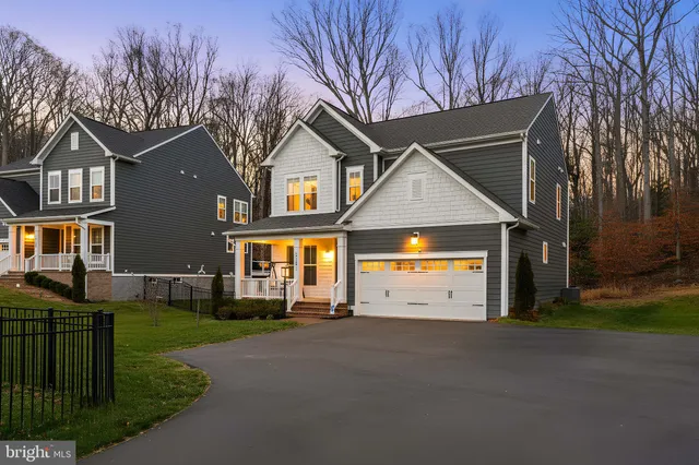 a view of a white house with a big yard and large trees