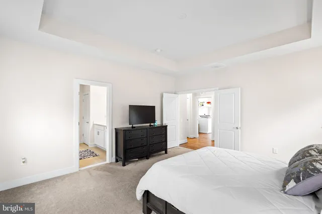 a bathroom with a toilet a sink a mirror a shower a vanity and window