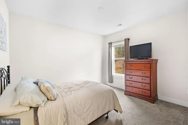 a view of a white house with a large yard and large trees
