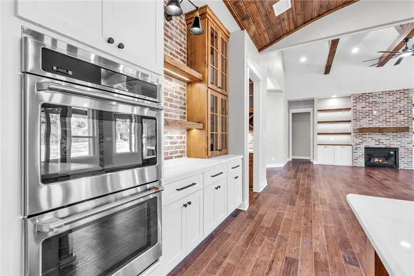 a kitchen with granite countertop a refrigerator and a stove top oven
