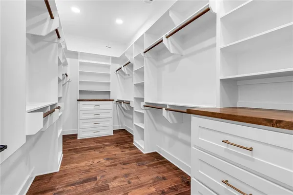 a view of walk in closet with clothes and shoes