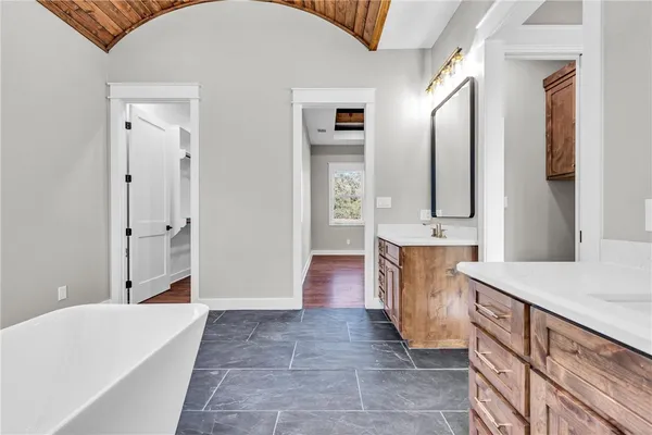 a bathroom with a bathtub a sink and a mirror