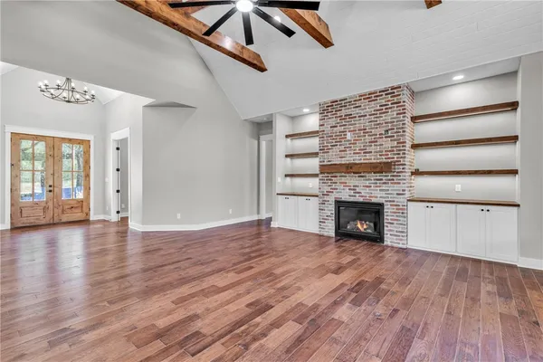 a view of empty room with wooden floor and fireplace