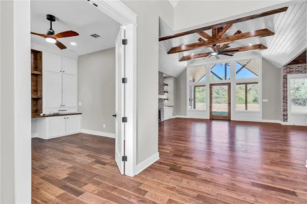 an empty room with wooden floor and windows