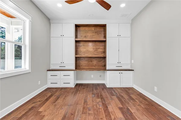 a view of room with wooden floor and cabinets