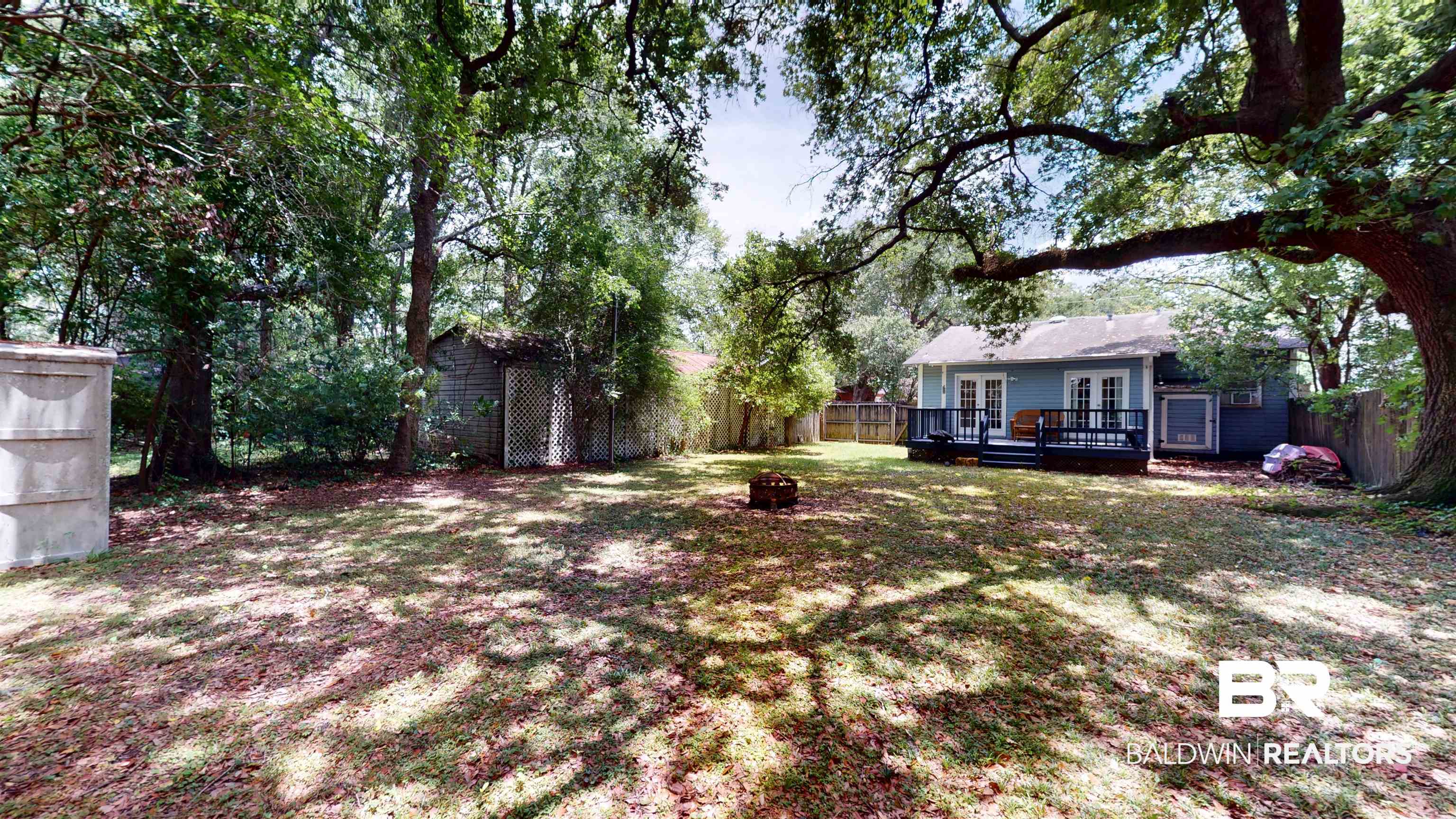 266 Westwood Street Mobile, AL 36606 - Photo 28 of 34 View of yard with french doors, a deck, and an outdoor fire pit
