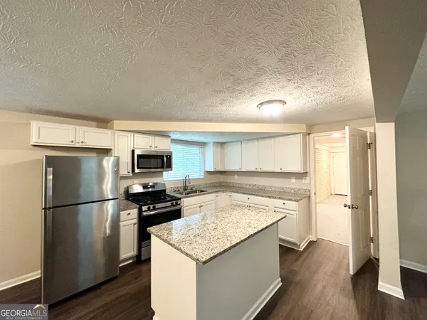 a kitchen with a refrigerator and a stove top oven