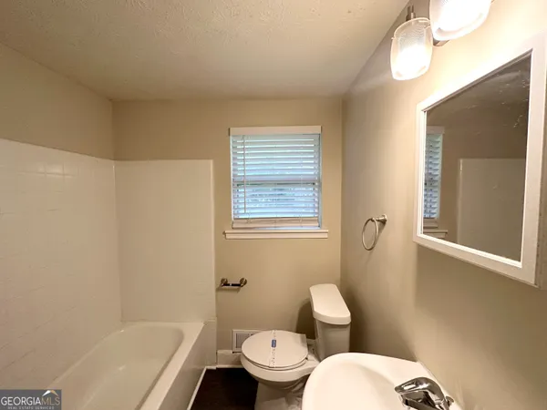a bathroom with a toilet a sink and bathtub
