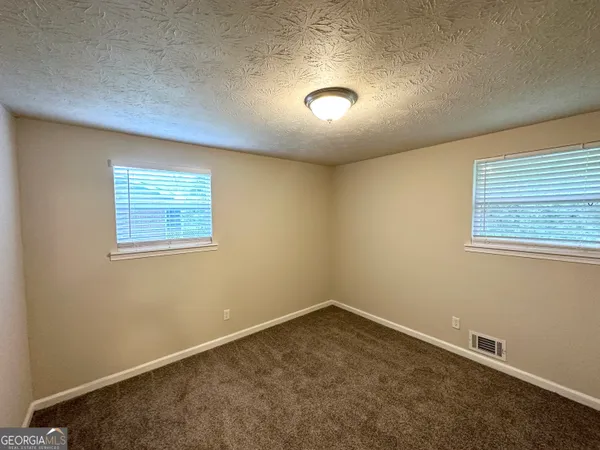 an empty room with a empty space and windows