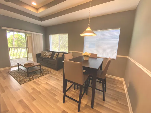 a dining room with furniture a chandelier and wooden floor