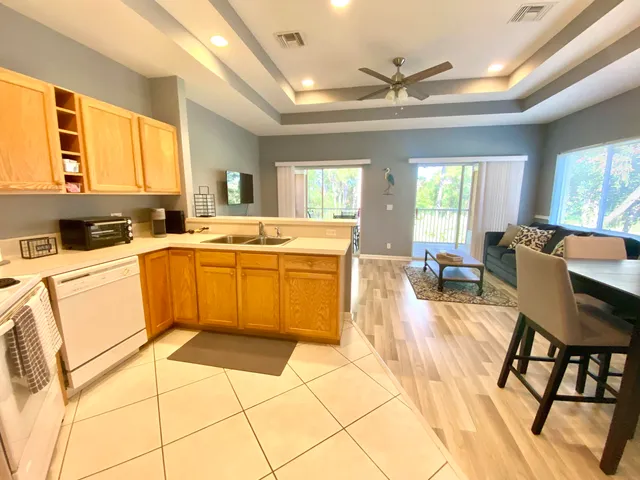a kitchen with a sink a stove cabinets dining table and chairs