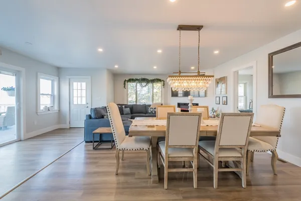 a dining room with furniture a chandelier and wooden floor