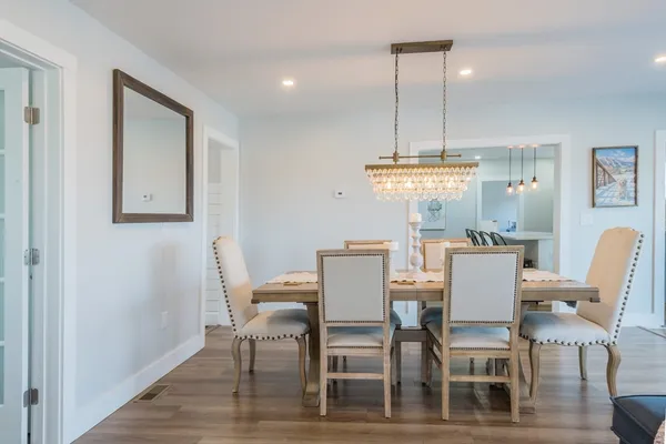 a dining room with furniture a chandelier and wooden floor