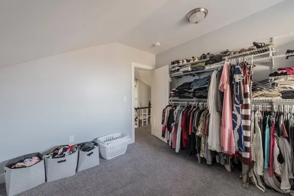 a view of walk in closet with clothes