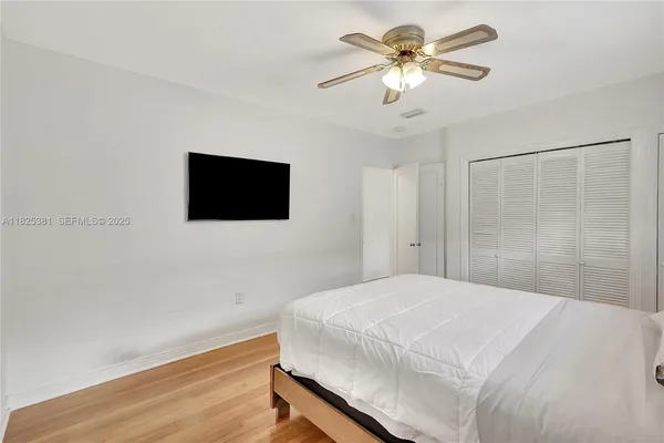 a bedroom with a bed and a flat screen tv