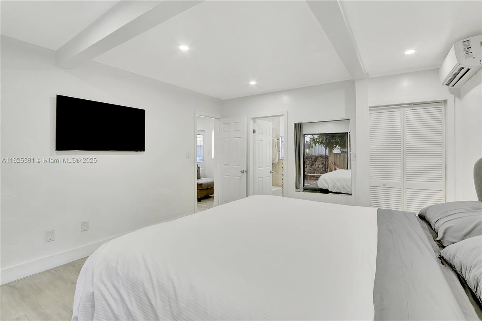 33 Southwest 20th Road Miami, FL 33129 - Photo 19 of 29 a bedroom with a bed a flat screen tv and a large window