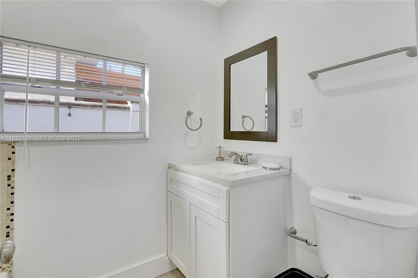 33 Southwest 20th Road Miami, FL 33129 - Photo 20 of 29 a bathroom with a toilet a sink a vanity and mirror