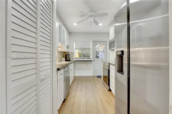 a kitchen with a refrigerator and white cabinets