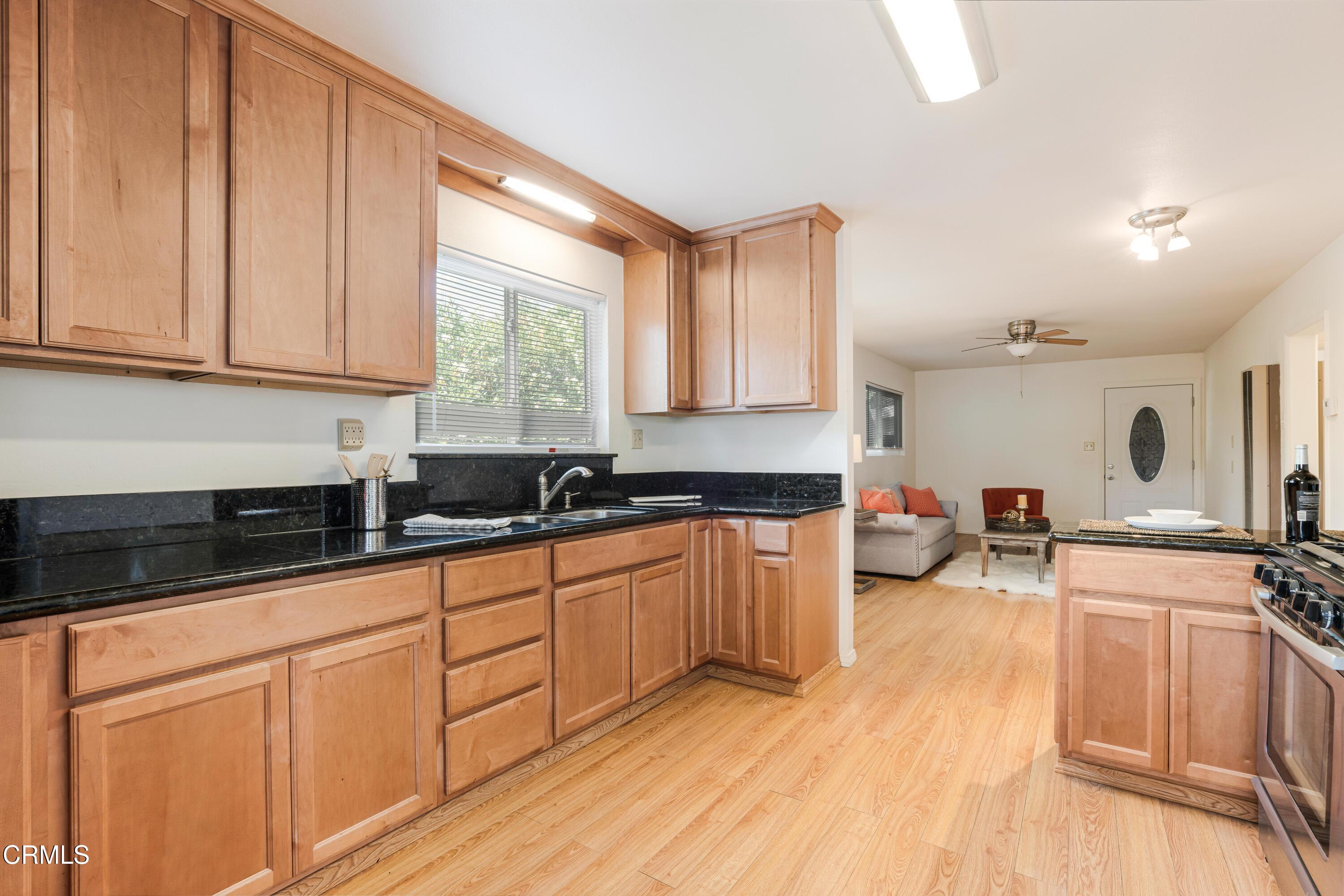467 Riverside Road Oak View, CA 93022 - Photo 48 of 65 a kitchen with granite countertop white cabinets and white appliances