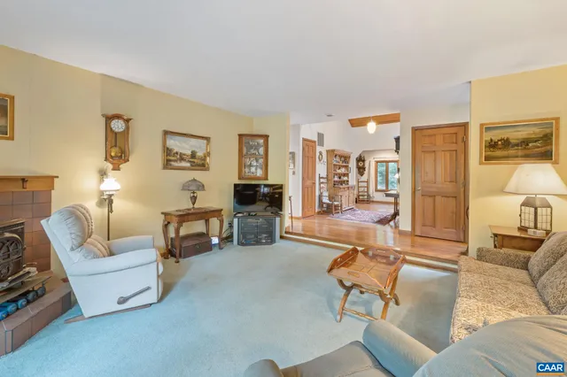 a living room with furniture a bookshelf and a window