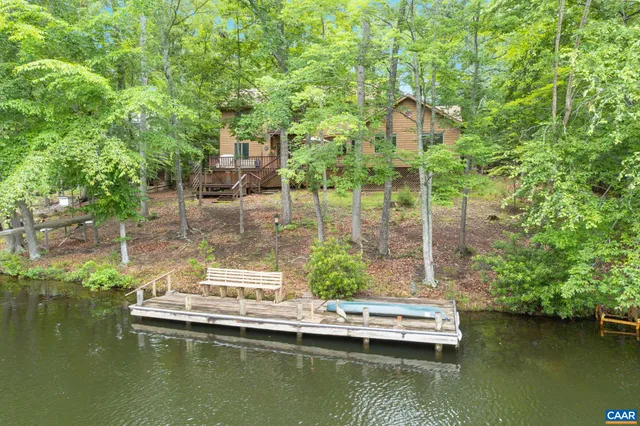 a view of swimming pool with outdoor seating lake and trees