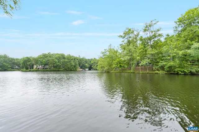 a aerial view of a house with a yard and table and chairs under an umbrella