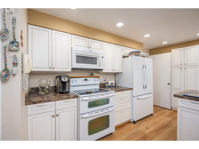 a kitchen with stainless steel appliances white cabinets and a refrigerator