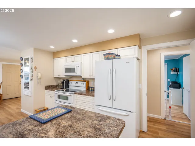 a open kitchen with stainless steel appliances kitchen island granite countertop a refrigerator and cabinets