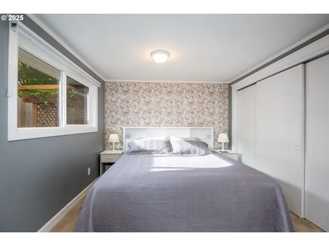 a bedroom with a bed and a large window