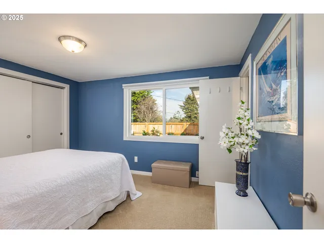 a bedroom with a large bed and wooden floor
