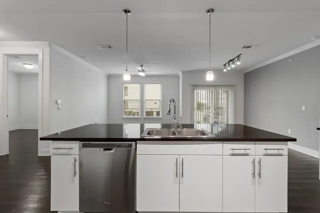 a kitchen with kitchen island granite countertop a sink a counter space appliances and cabinets