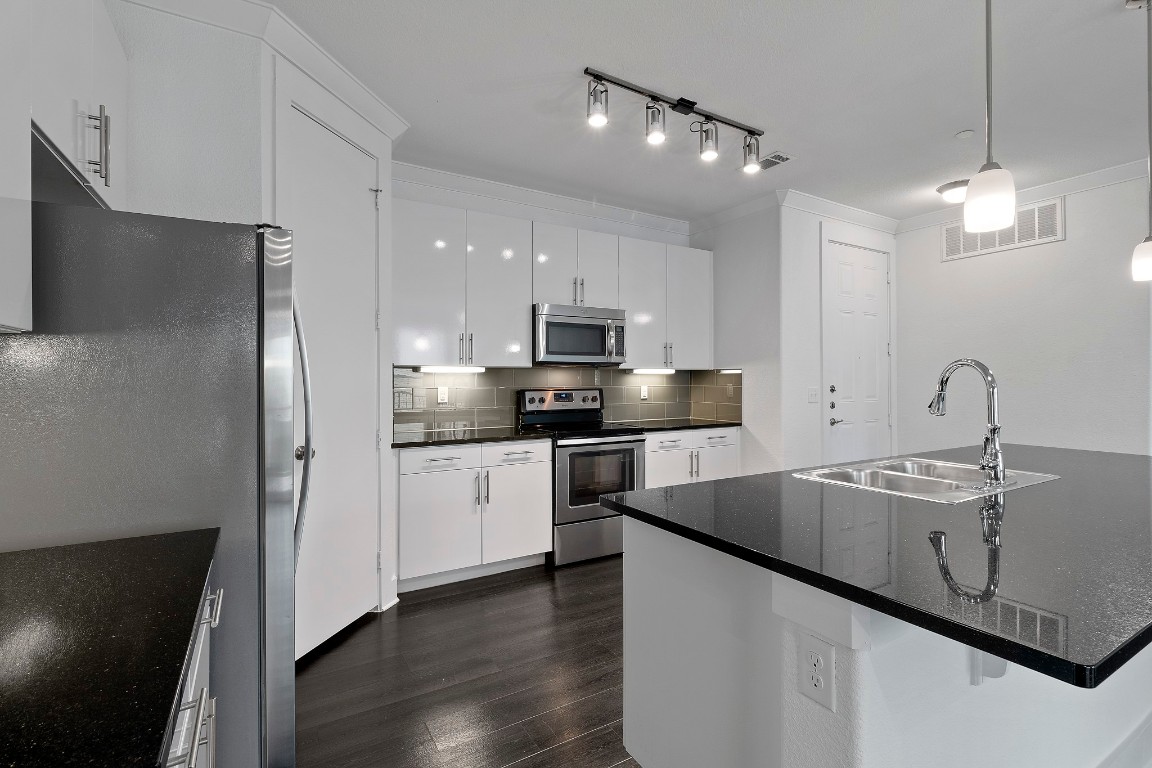 3300 Towers Boulevard, Unit 958 Seabrook, TX 77586 - Photo 14 of 33 a kitchen with stainless steel appliances granite countertop a sink a stove a refrigerator and island with wooden floor