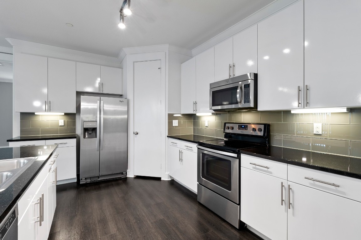 3300 Towers Boulevard, Unit 958 Seabrook, TX 77586 - Photo 3 of 33 a kitchen with stainless steel appliances granite countertop a stove a refrigerator and a microwave