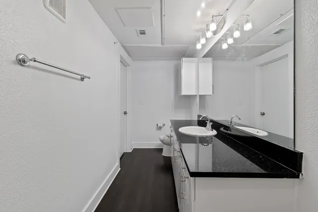 a kitchen with a sink dishwasher and a stove with wooden floor