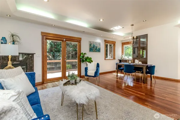 a living room with furniture large window and wooden floor