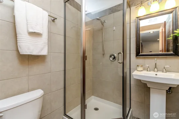 a bathroom with a sink a toilet and shower