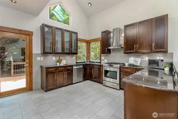 a kitchen with stainless steel appliances granite countertop a stove sink and cabinets