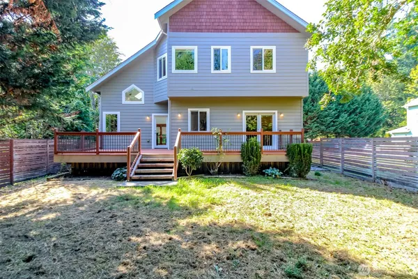 a view of a house with a yard and a wooden fence