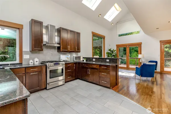 a kitchen with stainless steel appliances granite countertop a stove a sink dishwasher a refrigerator and a microwave oven with granite countertops