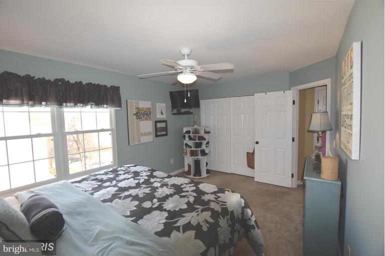 403 McDaniel Drive Purcellville, VA 20132 - Photo 7 of 13 a bedroom with a large bed and a chandelier