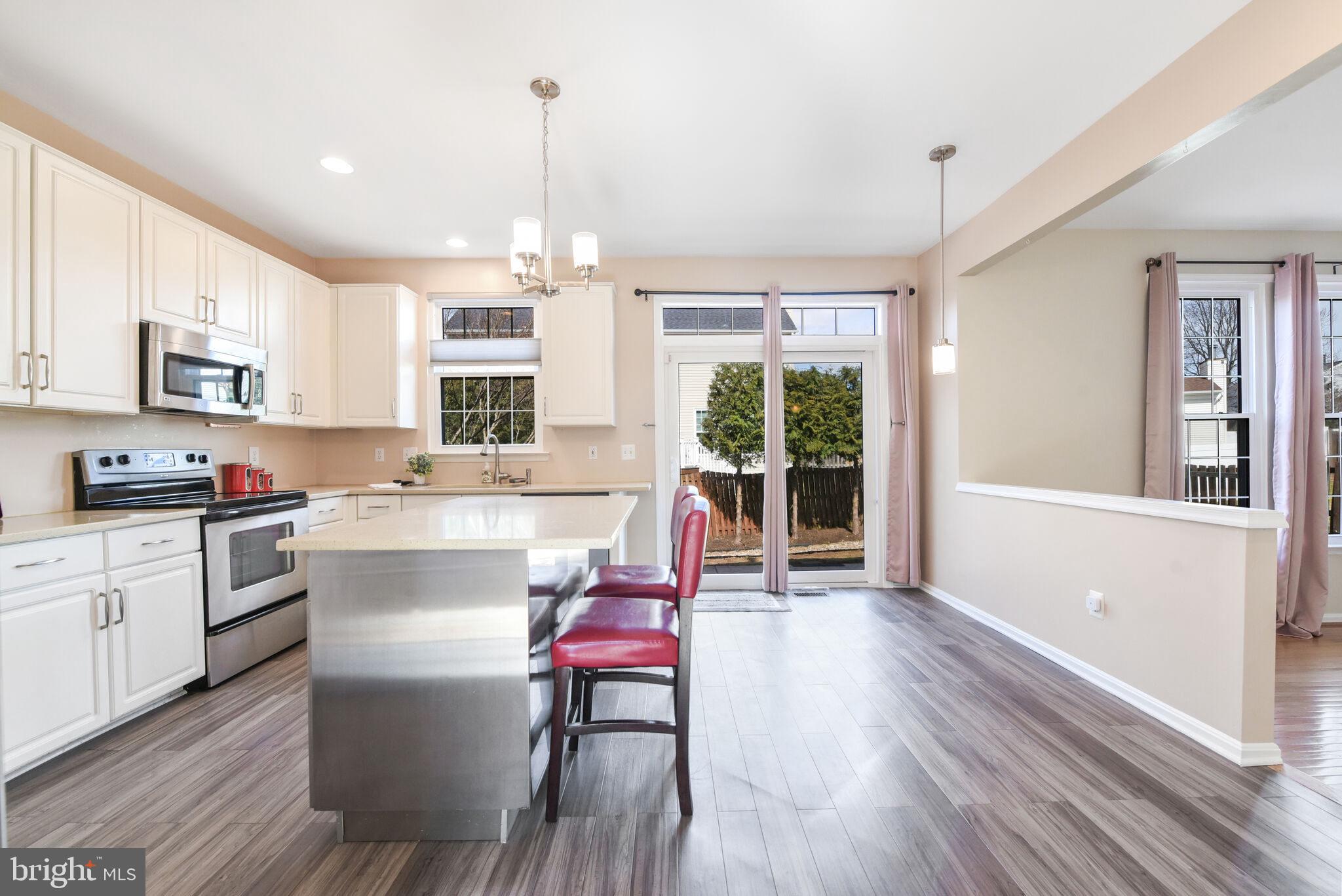 20907 Chippoaks Forest Circle Sterling, VA 20165 - Photo 12 of 71 a kitchen with a table chairs refrigerator and microwave