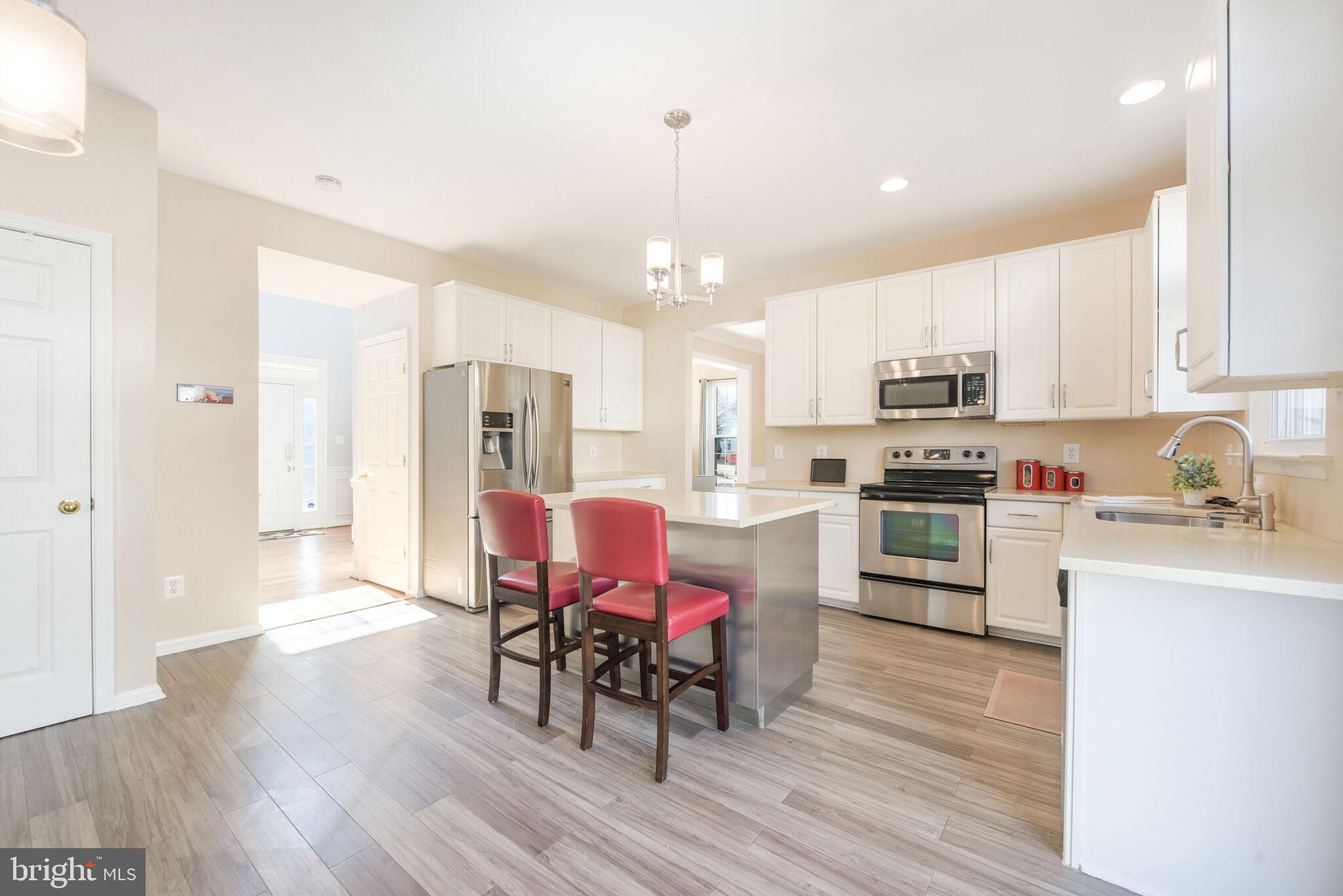 20907 Chippoaks Forest Circle Sterling, VA 20165 - Photo 13 of 71 a kitchen with cabinets wooden floor dining table and stainless steel appliances