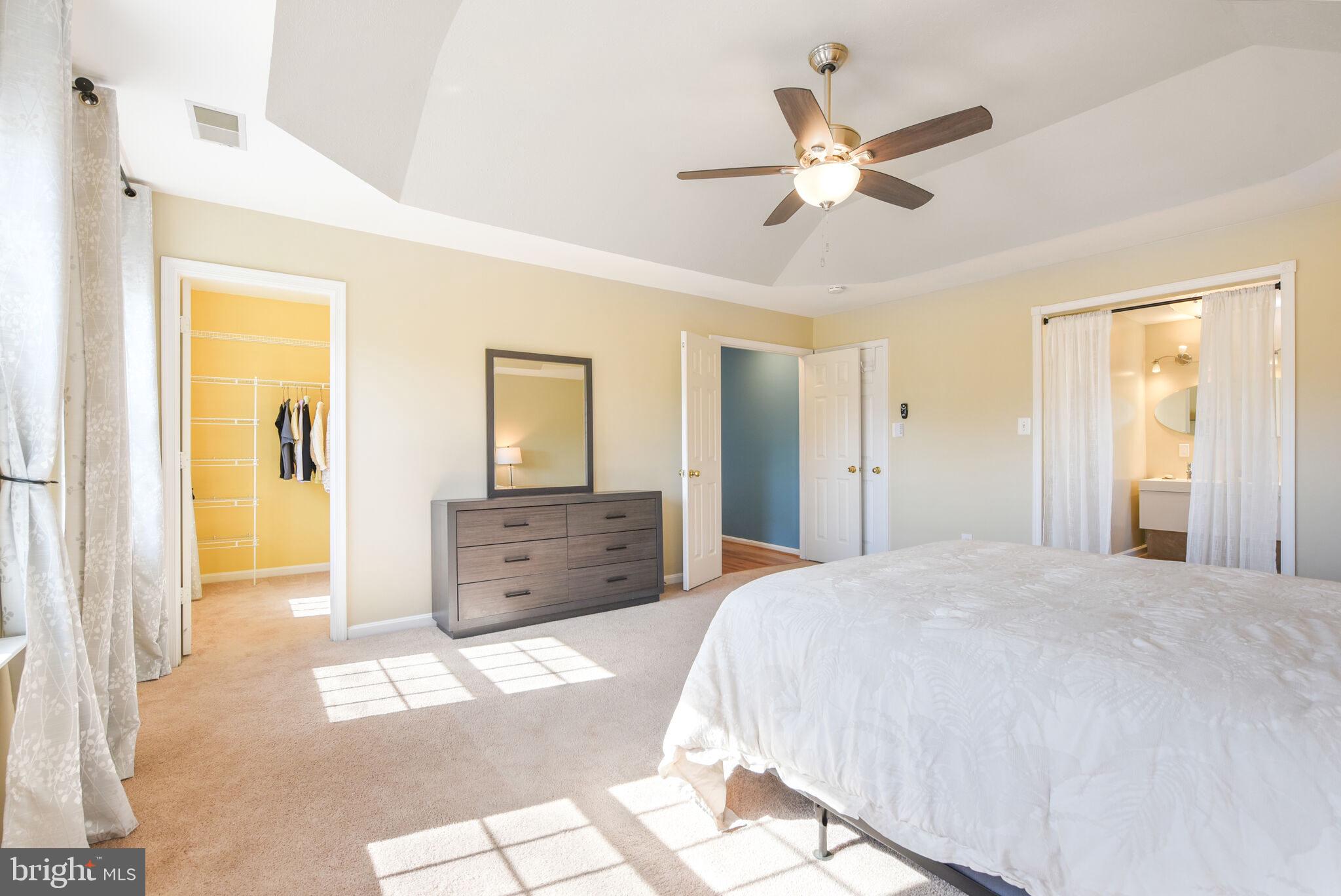20907 Chippoaks Forest Circle Sterling, VA 20165 - Photo 22 of 71 a spacious bedroom with a large bed and ceiling fan