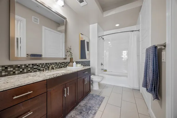 a bathroom with a granite countertop sink mirror and a bathtub