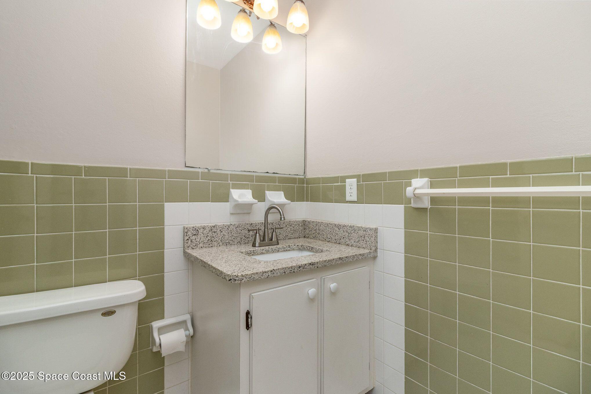 2863 Corbusier Drive Melbourne, FL 32935 - Photo 13 of 20 a bathroom with a sink a toilet and a mirror