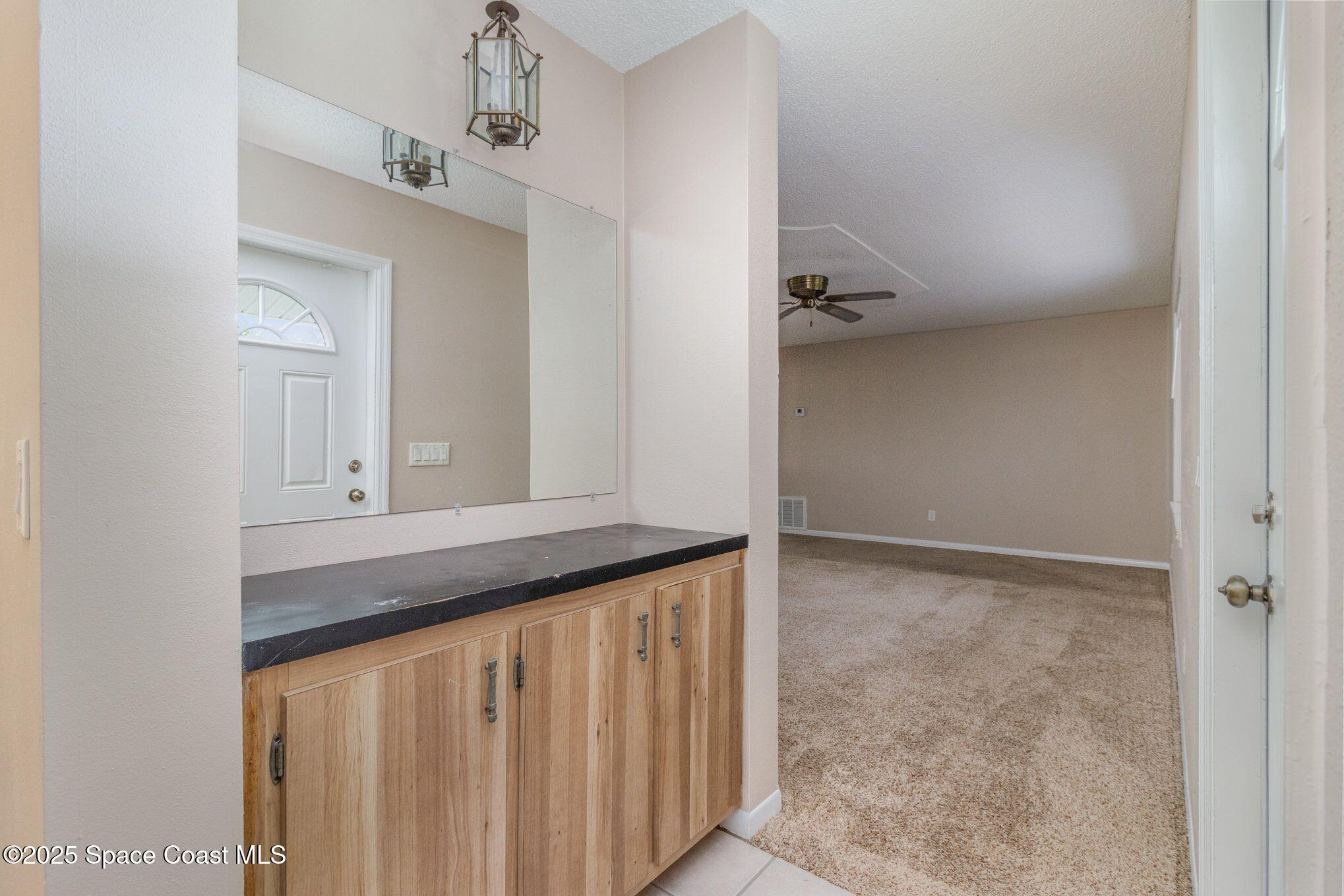2863 Corbusier Drive Melbourne, FL 32935 - Photo 2 of 20 a bathroom with a granite countertop sink and a mirror