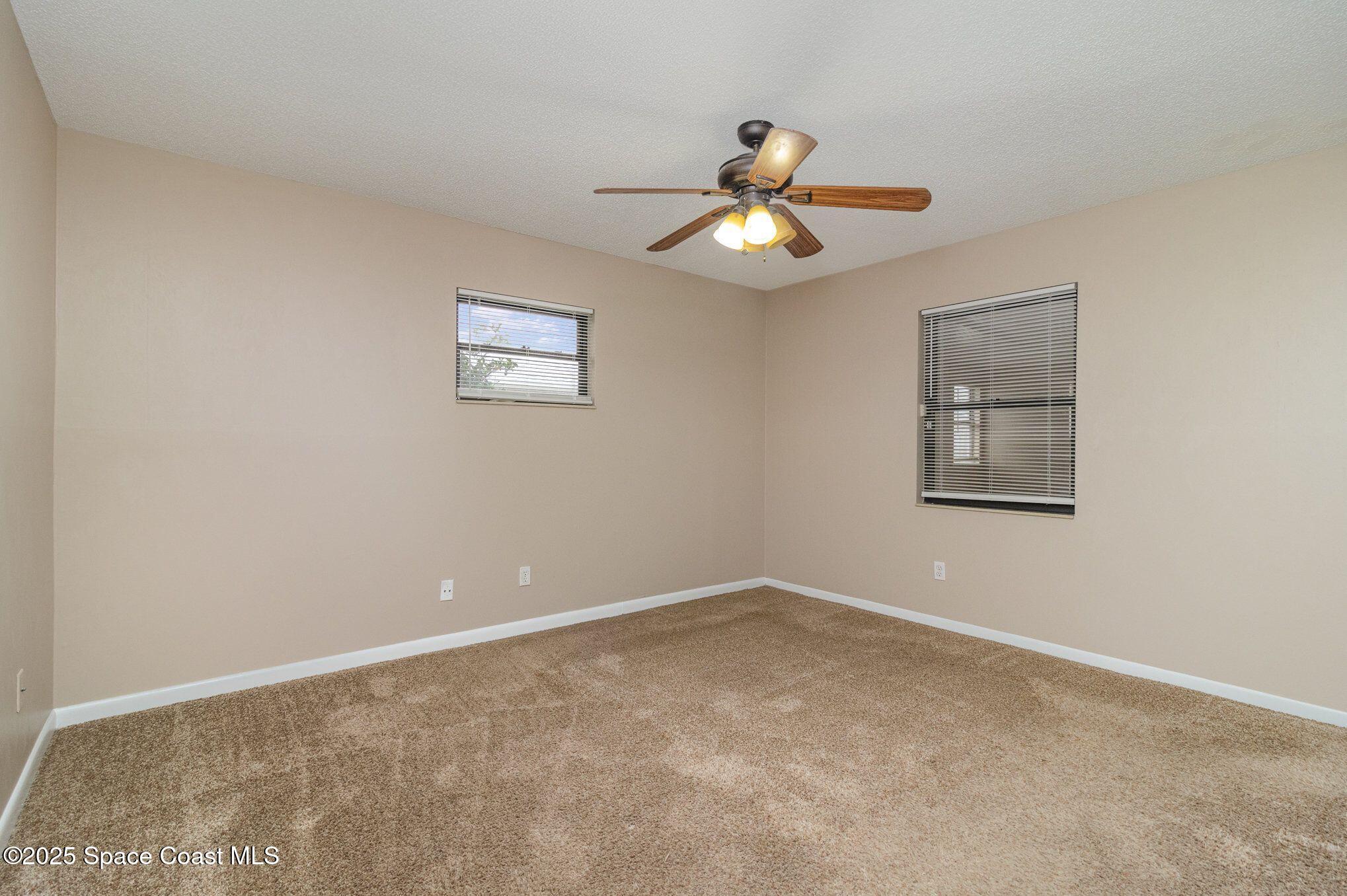 2863 Corbusier Drive Melbourne, FL 32935 - Photo 9 of 20 an empty room with a window and ceiling fan